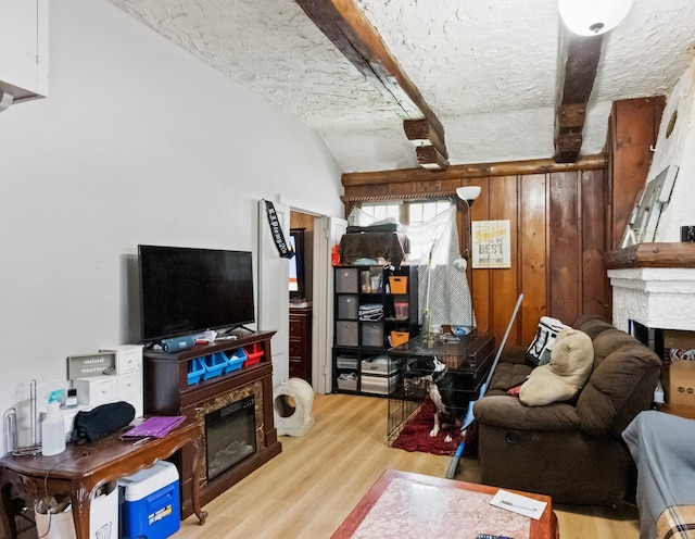 321 6th Ave E, Alexandria, MN 56308 - living area with a fireplace, light wood-style floors, beamed ceiling, a textured ceiling, and wood walls