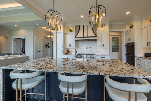1500 Weatherhill Ridge Ct SW, Rochester Twp, MN 55902 - kitchen with premium range hood, a chandelier, decorative backsplash, white cabinets, and recessed lighting