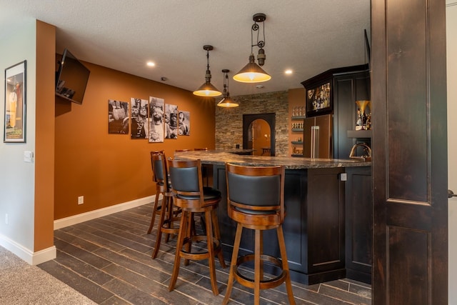 1500 Weatherhill Ridge Ct SW, Rochester Twp, MN 55902 - indoor wet bar featuring high quality fridge, recessed lighting, hanging light fixtures, a textured ceiling, and dark wood-type flooring
