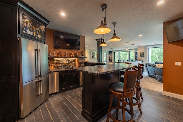 1500 Weatherhill Ridge Ct SW, Rochester Twp, MN 55902 - indoor wet bar with appliances with stainless steel finishes, dark wood-style flooring, recessed lighting, decorative light fixtures, and a textured ceiling