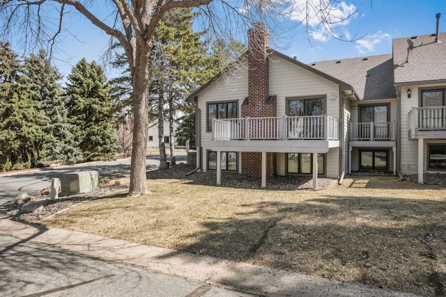 8425 Rice Lake Rd, Maple Grove, MN 55369 - rear view of property featuring a chimney, a lawn, and a balcony