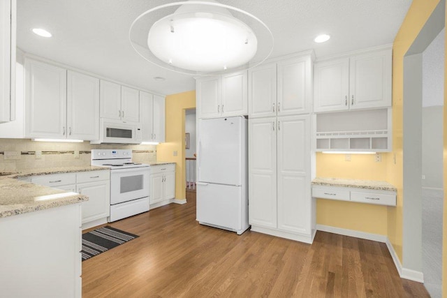 8425 Rice Lake Rd, Maple Grove, MN 55369 - kitchen featuring white appliances, white cabinetry, tasteful backsplash, light wood-style floors, and light stone counters