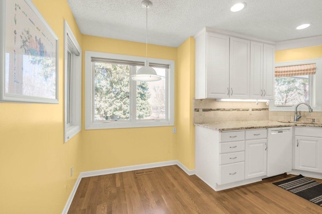 8425 Rice Lake Rd, Maple Grove, MN 55369 - kitchen featuring white dishwasher, backsplash, dark wood-type flooring, white cabinets, and plenty of natural light
