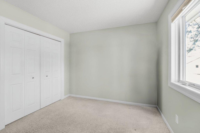8425 Rice Lake Rd, Maple Grove, MN 55369 - unfurnished bedroom featuring carpet flooring, a closet, and a textured ceiling