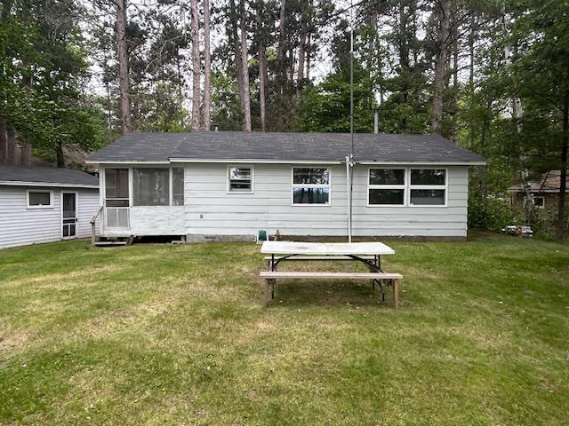 1906 Hay Lake Dr NW, Ponto Lake Twp, MN 56474 - rear view of house featuring a lawn, a sunroom, and view of scattered trees
