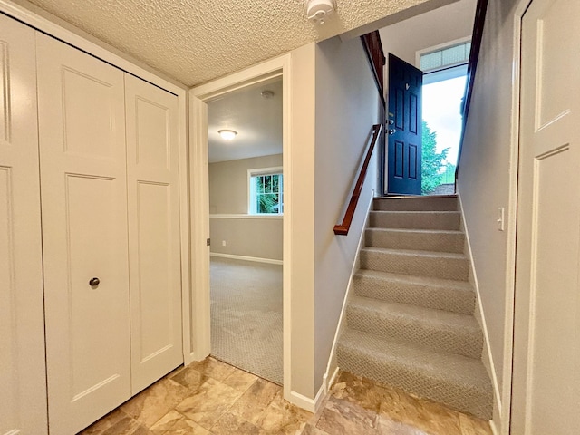 8389 Norwood Ln N, Maple Grove, MN 55369 - staircase with baseboards and a textured ceiling