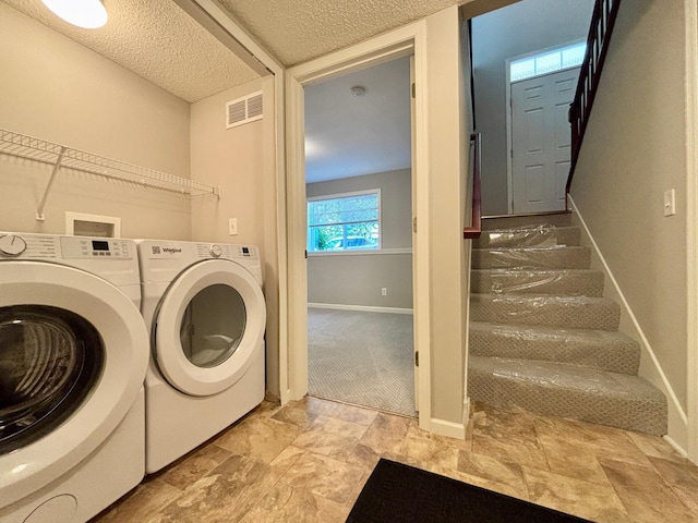 8389 Norwood Ln N, Maple Grove, MN 55369 - laundry room with a textured ceiling, washer and clothes dryer, and light stone finish floors