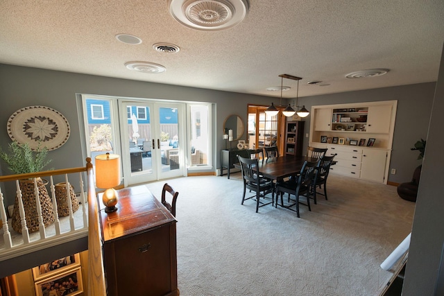 701 Oak Ave, Olivia, MN 56277 - dining area with carpet, a textured ceiling, and french doors