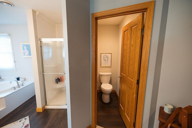 701 Oak Ave, Olivia, MN 56277 - bathroom featuring wood finished floors, a stall shower, and a bath