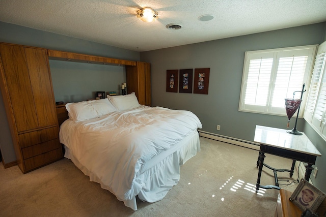 701 Oak Ave, Olivia, MN 56277 - bedroom featuring a baseboard heating unit, light carpet, and a textured ceiling