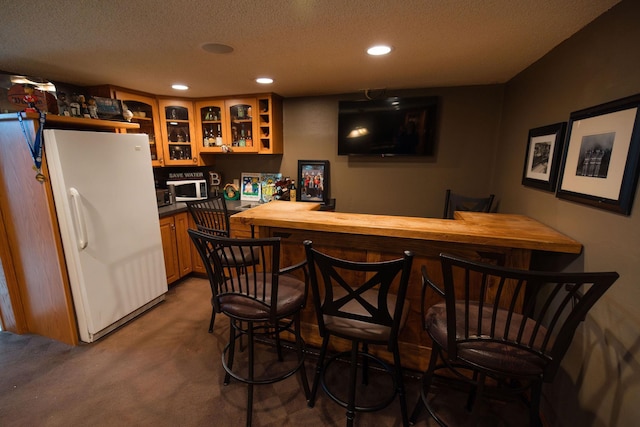 701 Oak Ave, Olivia, MN 56277 - indoor bar with white appliances, recessed lighting, carpet floors, and a textured ceiling