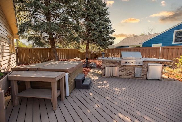 701 Oak Ave, Olivia, MN 56277 - deck at dusk with a hot tub, area for grilling, and a fenced backyard