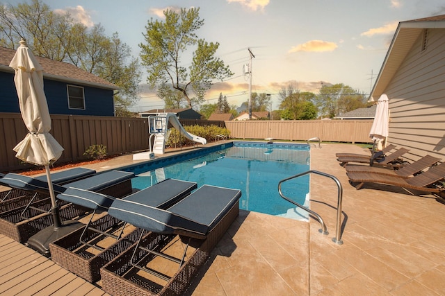 701 Oak Ave, Olivia, MN 56277 - view of swimming pool with a water slide, a fenced backyard, a patio area, and a diving board