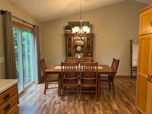 302 Peifer Dr, Litchfield, MN 55355 - dining room featuring lofted ceiling, a chandelier, and wood finished floors