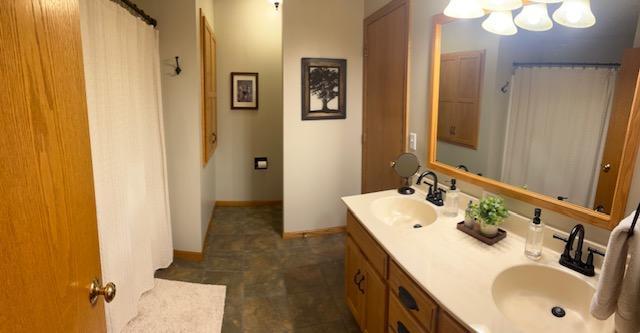 302 Peifer Dr, Litchfield, MN 55355 - bathroom featuring double vanity, a chandelier, and a shower with shower curtain