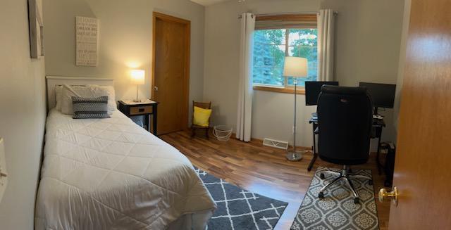 302 Peifer Dr, Litchfield, MN 55355 - bedroom featuring wood finished floors and an office area