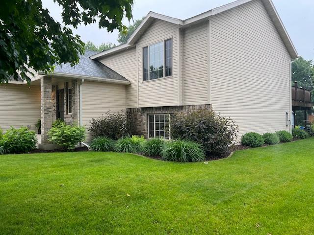 302 Peifer Dr, Litchfield, MN 55355 - view of home's exterior featuring a lawn and brick siding