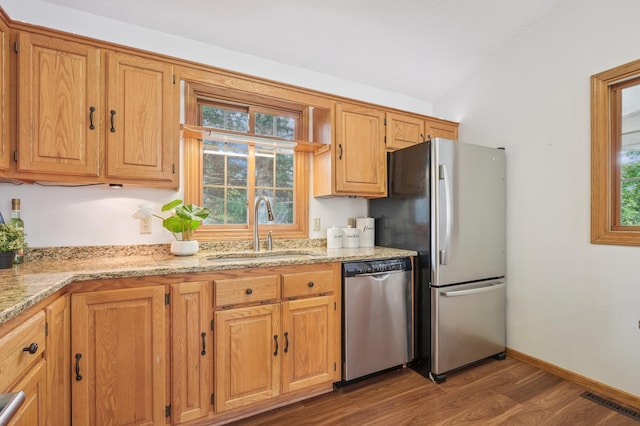 6936 Lake Ter E, Woodbury, MN 55125 - kitchen with appliances with stainless steel finishes, wood finished floors, plenty of natural light, vaulted ceiling, and light stone counters