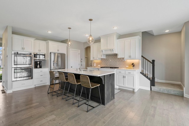 18175 61st Ave N, Plymouth, MN 55446 - kitchen featuring stainless steel appliances, light wood-type flooring, backsplash, a breakfast bar area, and recessed lighting