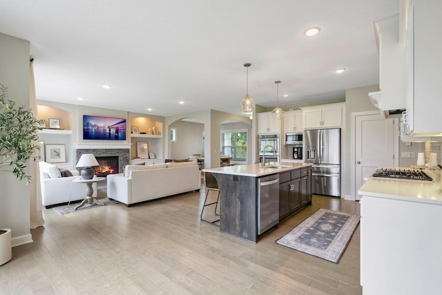 18175 61st Ave N, Plymouth, MN 55446 - kitchen with stainless steel appliances, light countertops, a stone fireplace, white cabinets, and recessed lighting