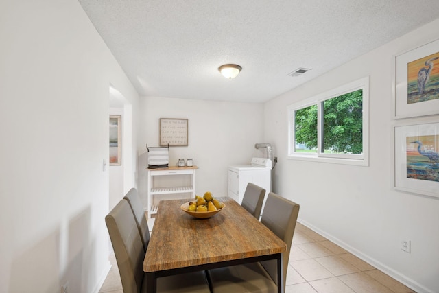 12908 Belle Aire Dr, Champlin, MN 55316 - dining space with washing machine and clothes dryer, a textured ceiling, and light tile patterned floors