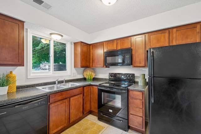 12908 Belle Aire Dr, Champlin, MN 55316 - kitchen featuring black appliances, dark countertops, brown cabinetry, and a textured ceiling