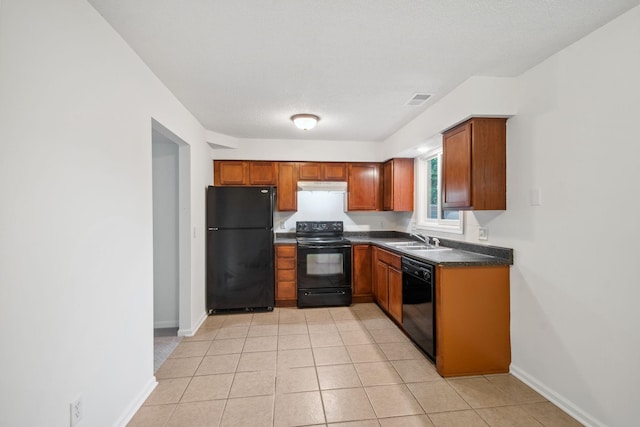 12908 Belle Aire Dr, Champlin, MN 55316 - kitchen with black appliances, dark countertops, under cabinet range hood, brown cabinets, and light tile patterned floors
