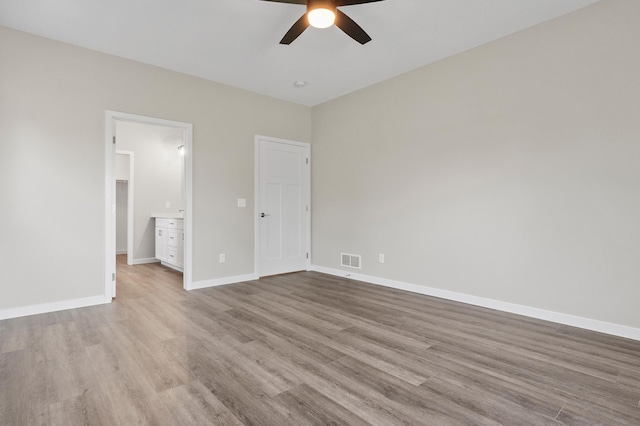 1720 Summer Ln NE, Alexandria, MN 56308 - unfurnished bedroom featuring wood finished floors, connected bathroom, and ceiling fan