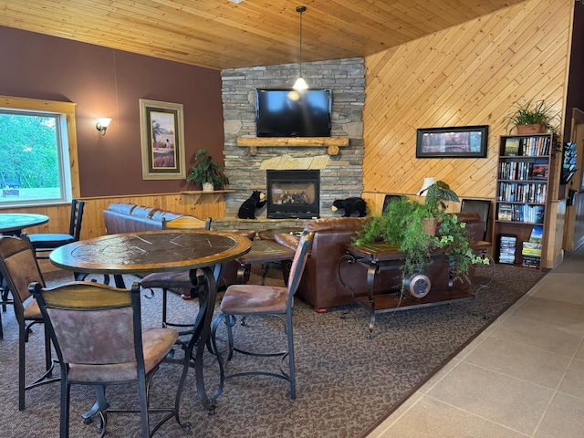 1540 US Highway 59 Unit 203, Detroit Lakes, MN 56501 - dining room featuring wooden walls, a stone fireplace, wooden ceiling, tile patterned floors, and a wainscoted wall