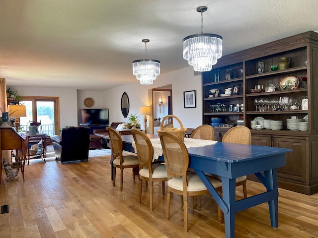 4887 Tee Ct SW, Rochester, MN 55902 - dining room with a chandelier, light wood finished floors, and a textured ceiling