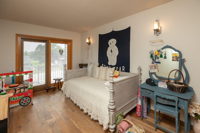 4887 Tee Ct SW, Rochester, MN 55902 - bedroom with wood finished floors, access to exterior, and a textured ceiling