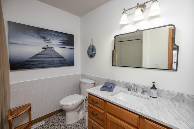 4887 Tee Ct SW, Rochester, MN 55902 - bathroom with vanity, tile walls, a wainscoted wall, and a shower