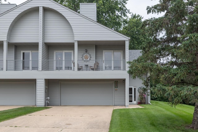 4887 Tee Ct SW, Rochester, MN 55902 - view of front facade with driveway, a chimney, a front lawn, an attached garage, and a balcony