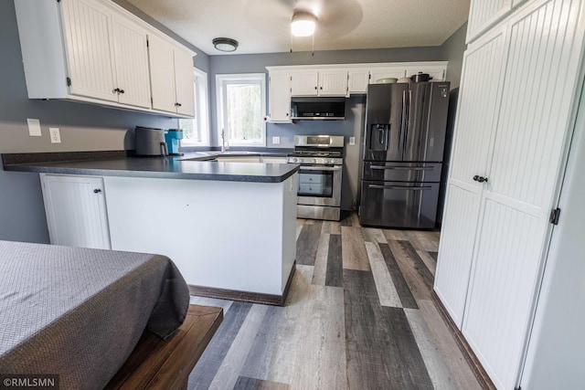 6354 151st Street Ct N, Hugo, MN 55038 - kitchen featuring stainless steel gas range, refrigerator with ice dispenser, black microwave, dark countertops, and dark wood-style floors