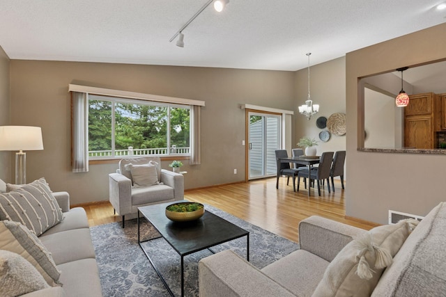 6160 Creek View Rdg, Minnetonka, MN 55345 - living area featuring lofted ceiling, a chandelier, rail lighting, and wood finished floors