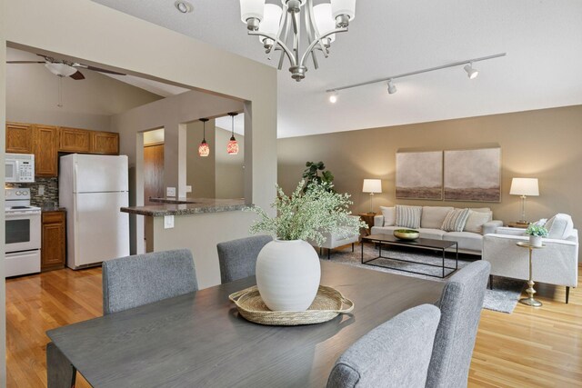 6160 Creek View Rdg, Minnetonka, MN 55345 - dining space with track lighting, light wood-style flooring, vaulted ceiling, a chandelier, and ceiling fan