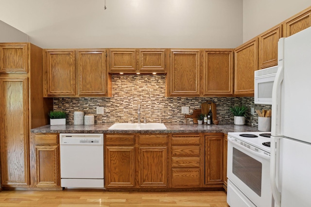 6160 Creek View Rdg, Minnetonka, MN 55345 - kitchen with white appliances, decorative backsplash, dark countertops, light wood finished floors, and brown cabinets