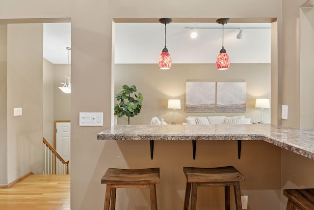 6160 Creek View Rdg, Minnetonka, MN 55345 - kitchen featuring a breakfast bar, decorative light fixtures, track lighting, and wood finished floors