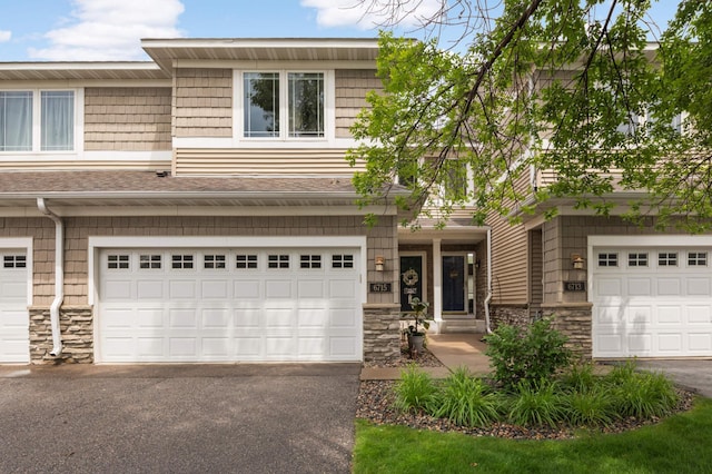 6715 158th St W, Apple Valley, MN 55124 - view of front of home featuring stone siding, a garage, driveway, and a shingled roof