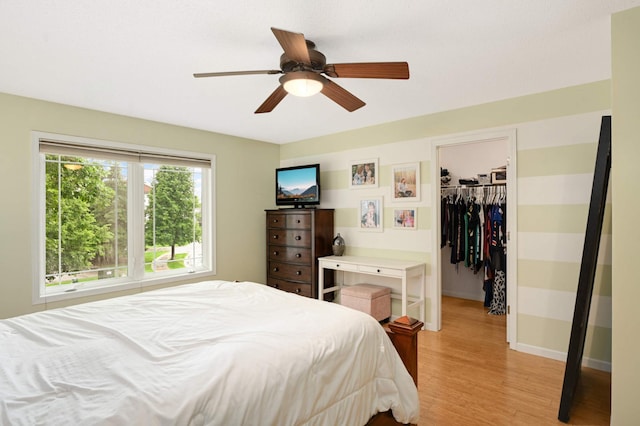 6715 158th St W, Apple Valley, MN 55124 - bedroom featuring light wood-style flooring, a walk in closet, a closet, and ceiling fan