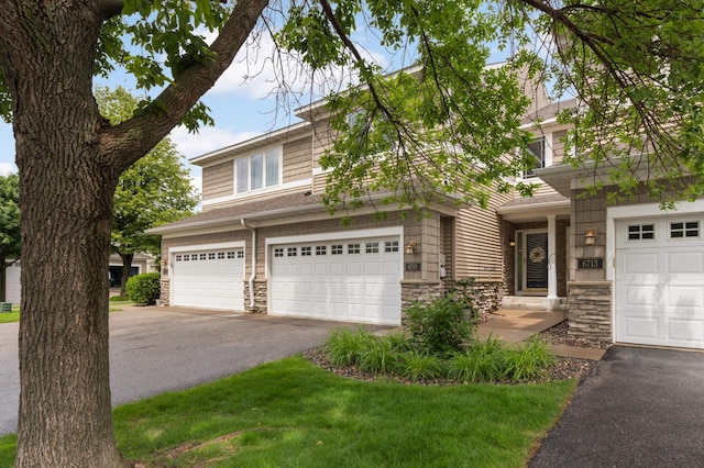 6715 158th St W, Apple Valley, MN 55124 - view of front of property featuring stone siding, asphalt driveway, and a garage