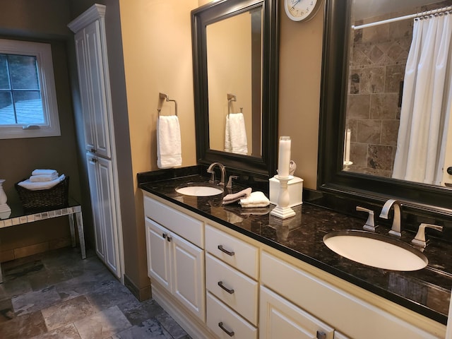 3900 Hillcrest Way, Deephaven, MN 55391 - bathroom featuring double vanity, a tile shower, stone finish floors, and ornate columns