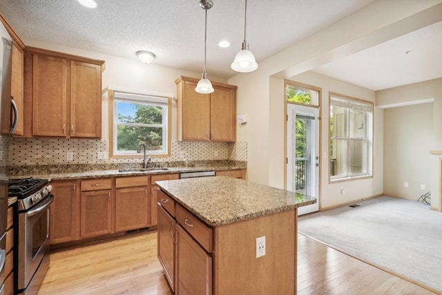 10751 Falling Water Ln Unit C, Woodbury, MN 55129 - kitchen with gas range, decorative backsplash, light stone counters, a kitchen island, and light wood finished floors