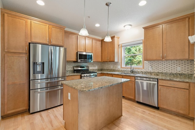 10751 Falling Water Ln Unit C, Woodbury, MN 55129 - kitchen with stainless steel appliances, light wood finished floors, light stone counters, a center island, and decorative backsplash