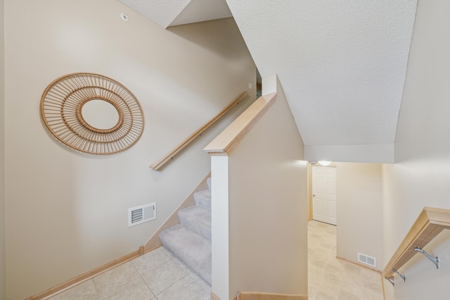 10751 Falling Water Ln Unit C, Woodbury, MN 55129 - staircase featuring tile patterned flooring, a textured ceiling, and lofted ceiling