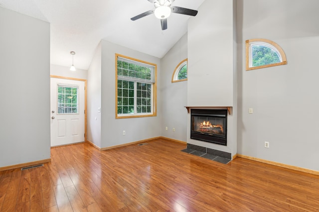 18267 Coneflower Ln, Eden Prairie, MN 55346 - unfurnished living room featuring vaulted ceiling, healthy amount of natural light, wood finished floors, a multi sided fireplace, and ceiling fan