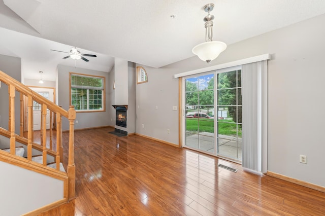 18267 Coneflower Ln, Eden Prairie, MN 55346 - unfurnished living room with wood finished floors, healthy amount of natural light, ceiling fan, stairs, and vaulted ceiling