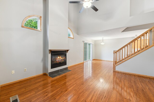 18267 Coneflower Ln, Eden Prairie, MN 55346 - unfurnished living room featuring plenty of natural light, stairway, a high ceiling, and wood-type flooring
