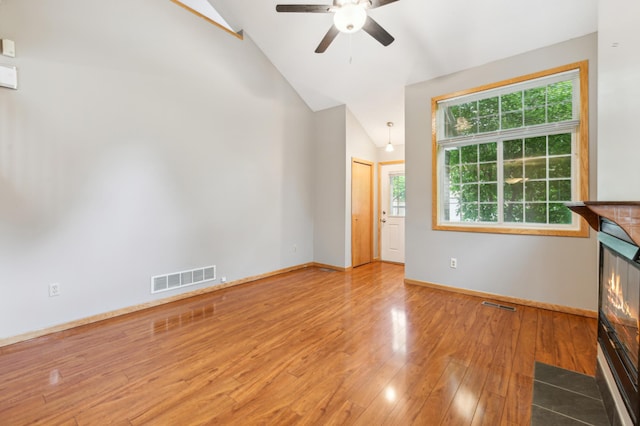 18267 Coneflower Ln, Eden Prairie, MN 55346 - unfurnished living room with a ceiling fan, wood finished floors, high vaulted ceiling, and a glass covered fireplace