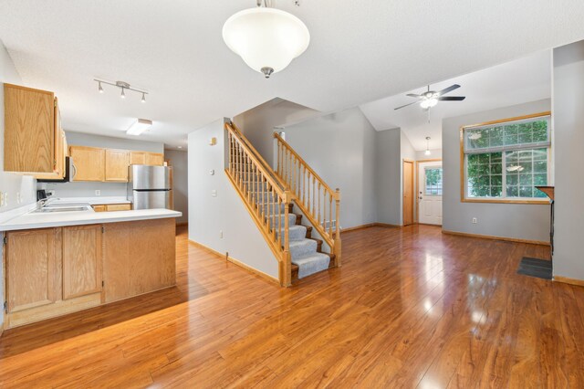 18267 Coneflower Ln, Eden Prairie, MN 55346 - kitchen with freestanding refrigerator, a peninsula, light wood-style floors, ceiling fan, and light countertops